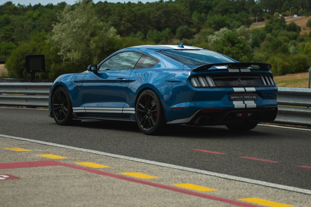 Blue Ford Mustang photographed at a racetrack; illustrative vehicle example