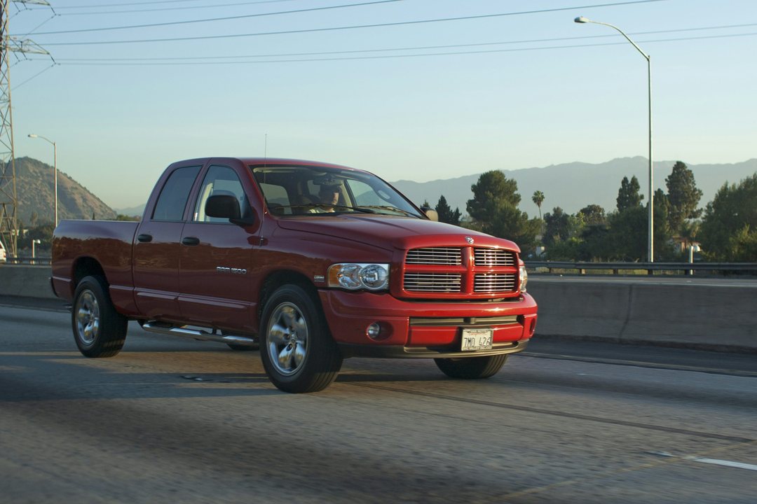 Red RAM pickup driving on a road; illustrative vehicle example